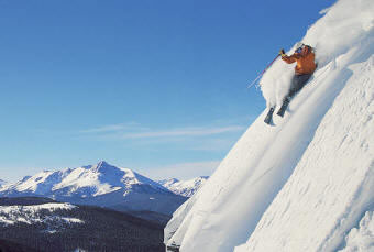 Skier Sliding Down On Steep Snow Slope by Stocksy Contributor Ibex.media  - Stocksy